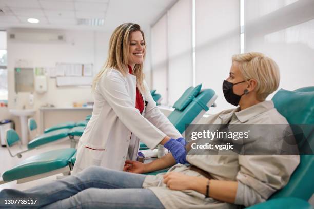 woman donating blood in hospital donation bank - blood bag stock pictures, royalty-free photos & images