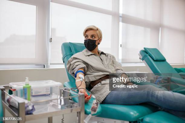 woman donating blood in hospital donation bank - blood bank imagens e fotografias de stock