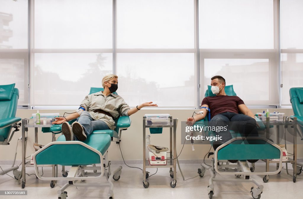 Pareja donando sangre juntos