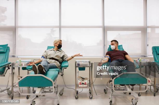 couple donating blood together - blood plasma stock pictures, royalty-free photos & images