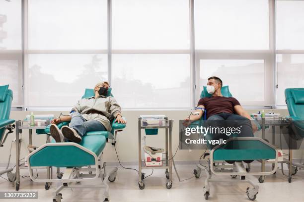 couple donating blood together - blood bank stock pictures, royalty-free photos & images