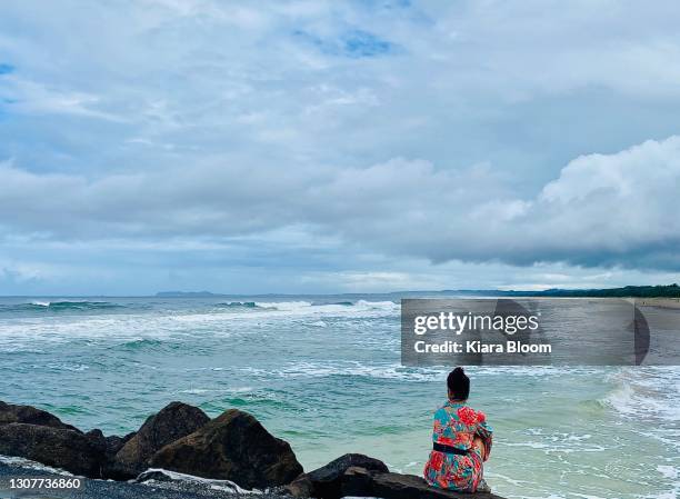 ocean views for person sitting on promenade rock wall - oceana stock pictures, royalty-free photos & images