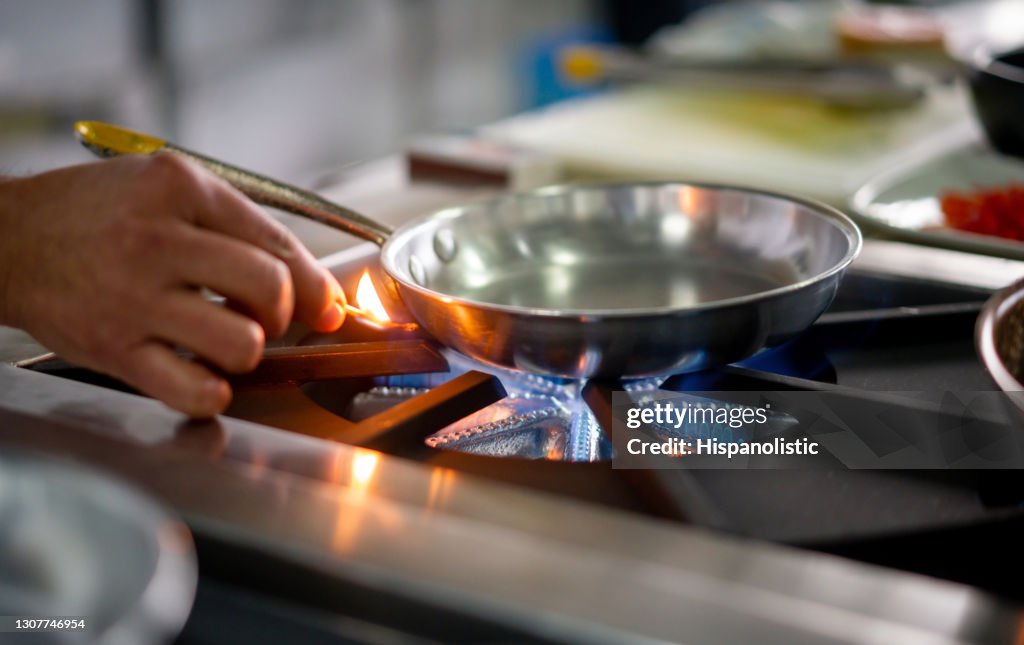 Chef lighting up a gas stove burner with a match