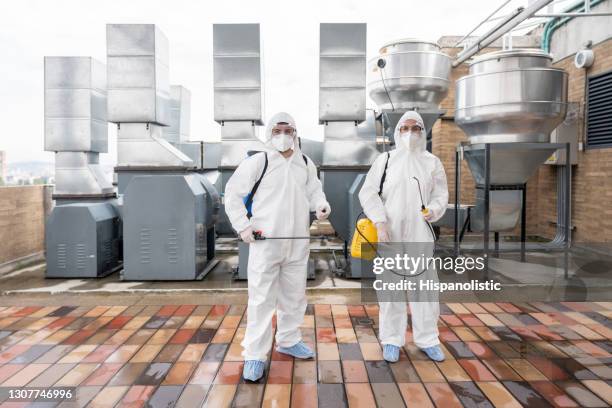 nettoyeurs professionnels désinfectant des machines à une usine - fumigation photos et images de collection