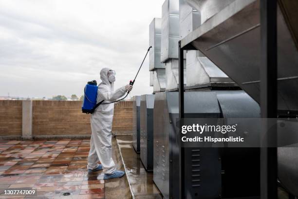 limpiador profesional desinfectando respiraderos de aire en una fábrica - disinfection fotografías e imágenes de stock