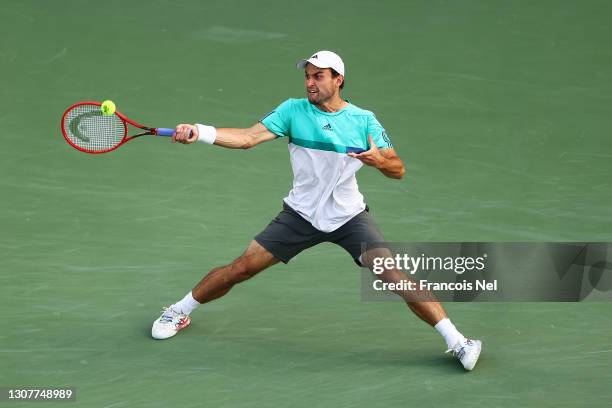 Aslan Karatsev of Russia plays a forehand in his Quarter-Final singles match against Jannik Sinner of Italy during Day Twelve of the Dubai Duty Free...