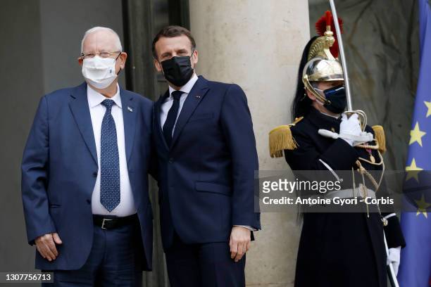French President Emmanuel Macron and President of Israel Reuven Rivlin wearing protective face masks wave prior to their meeting at the Elysee...