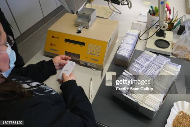 Lab worker uses a machine to count out 100 seeds at a time before sprouting the seeds to test their viability following prolonged cold storage at -18...