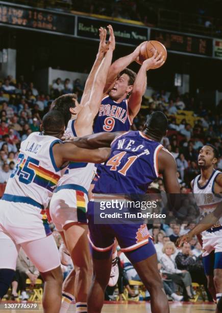 Dan Majerle, Shooting Guard and Small Forward for the Phoenix Suns attempts a jump shot as Blair Rasmussen of the Denver Nuggets tries to block...