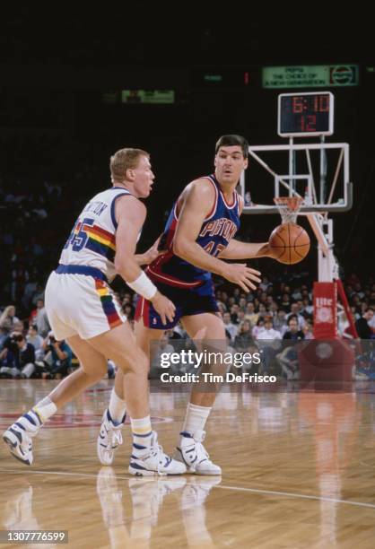 Bill Laimbeer, Center for the Detroit Pistons dribbles the basketball around Tim Kempton of the Denver Nuggets during their NBA Midwest Division...