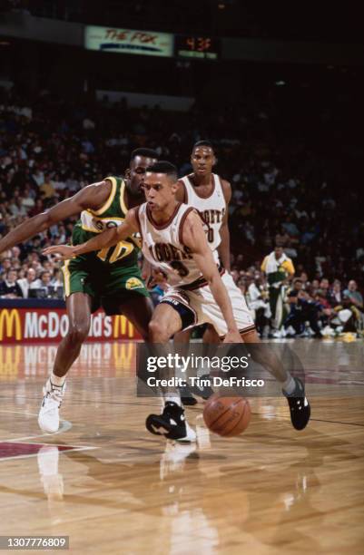 Mahmoud Abdul-Rauf, Point Guard for the Denver Nuggets dribbles the basketball around Nate McMillan of the Seattle SuperSonics during their NBA...