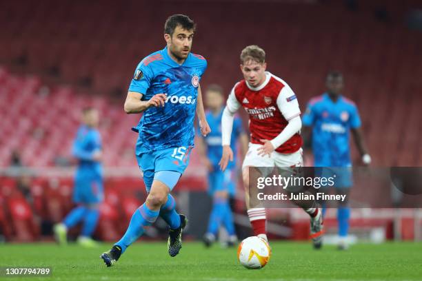 Sokratis Papastathopoulos of Olympiakos runs with the ball whilst under pressure from Emile Smith Rowe of Arsenal during the UEFA Europa League Round...