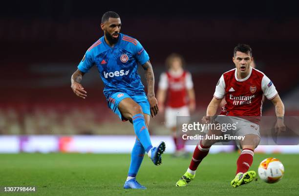 Yann M'Vila of Olympiakos makes a pass whilst under pressure from Granit Xhaka of Arsenal during the UEFA Europa League Round of 16 Second Leg match...