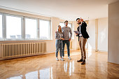 Real estate agent showing an apartment for sale to a young couple