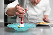 Professional chef holding a foam siphon in a restaurant kitchen. High quality photo