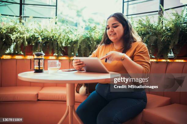 mujer pagando en línea con su tarjeta de crédito - chubby credit fotografías e imágenes de stock