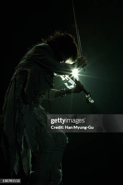 Japanese guitarist Sugizo of the band X Japan play violin performs during a concert at Olympic Gymnasium on October 28, 2011 in Seoul, South Korea.