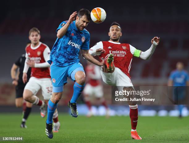 Sokratis Papastathopoulos of Olympiakos battles for possession with Pierre Emerick Aubameyang of Arsenal during the UEFA Europa League Round of 16...