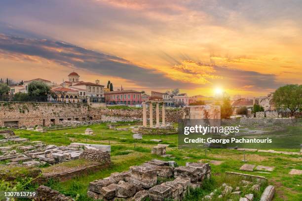 sunset over the hadrian library archaeological site in athens, greece - plaka stockfoto's en -beelden