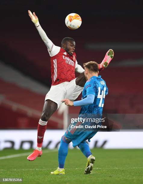 Nicolas Pepe of Arsenal is challenged by Oleg Reabciuk of Olympiacos during the UEFA Europa League Round of 16 Second Leg match between Arsenal and...