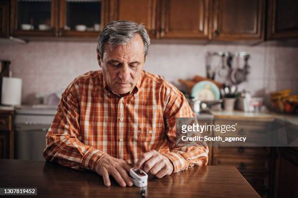 senior mann sauerstoffgehalt in seinem blut - puls oxymeter stock-fotos und bilder