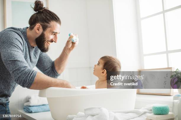 baby's bath time - man bathing stock pictures, royalty-free photos & images