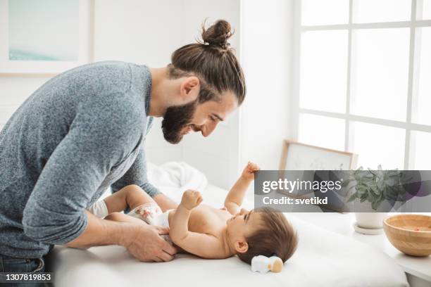 het veranderen van luier aan zijn babymeisje - nappy change stockfoto's en -beelden