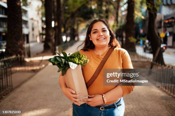 portrait of woman holding groceries - mexican street market stock pictures, royalty-free photos & images