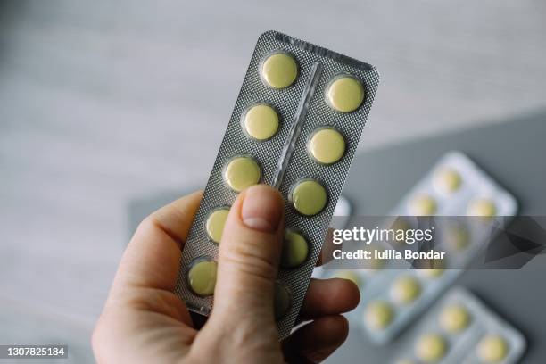 female hand hold pack of yellow tablet blisters. - anti histamínico - fotografias e filmes do acervo