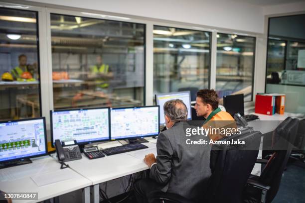 manager and worker monitoring computers at waste facility - control room stock pictures, royalty-free photos & images