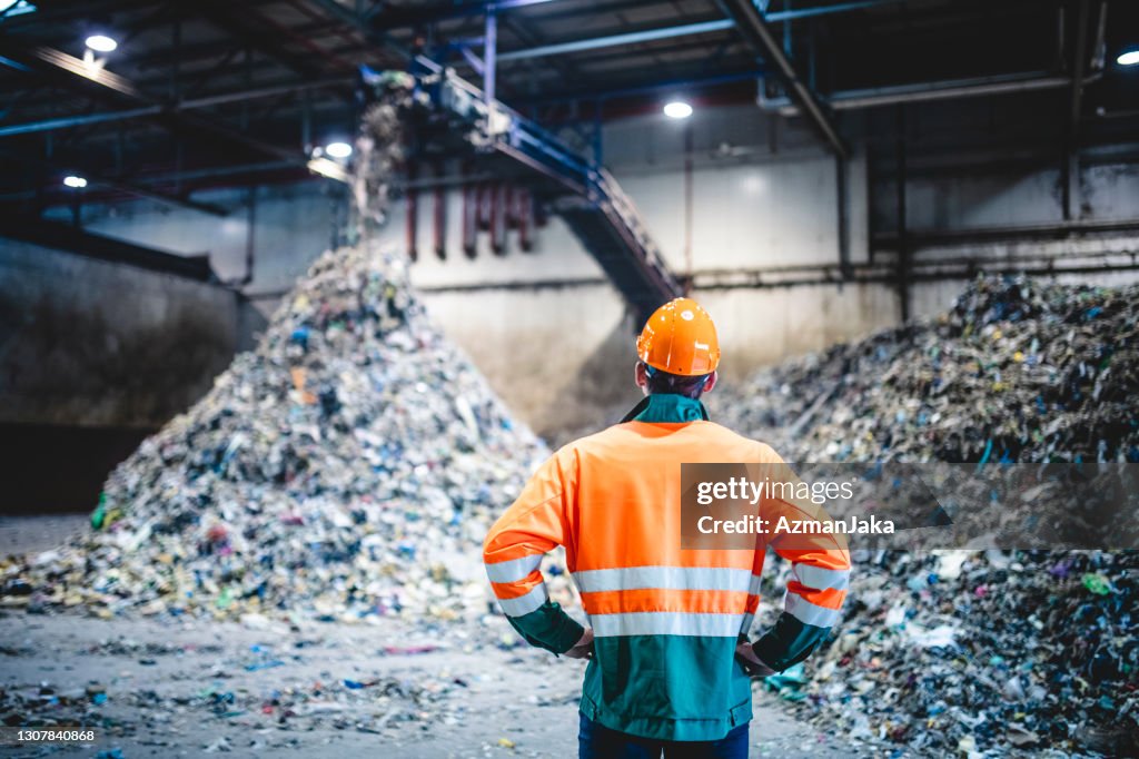 Männlicher Arbeiter in Schutzausrüstung in der Abfallaufbereitungsanlage
