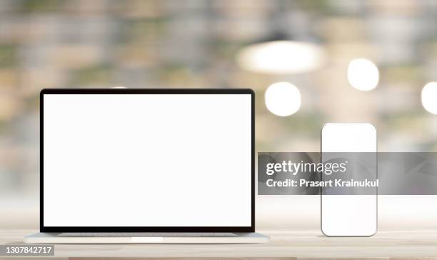 laptop with blank screen and smartphone on table. mockup - office front desk stock-fotos und bilder