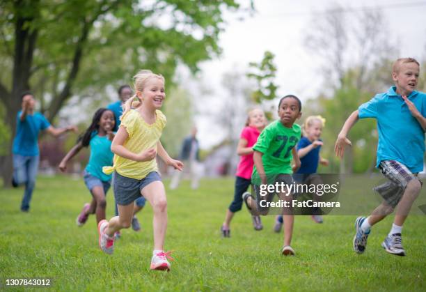 multi ethnische gruppe von kindern läuft in einem park im freien - ferienlager stock-fotos und bilder
