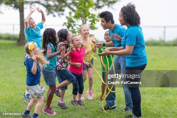 camp counsellors and children getting ready for tug-of-war game - summer camp kids stock pictures, royalty-free photos & images