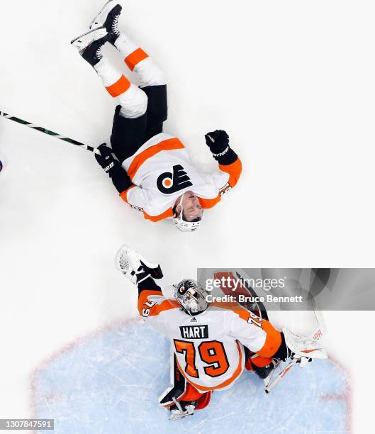 Justin Braun and Carter Hart of the Philadelphia Flyers defend the net against the New York Islanders at the Nassau Coliseum on March 18, 2021 in...