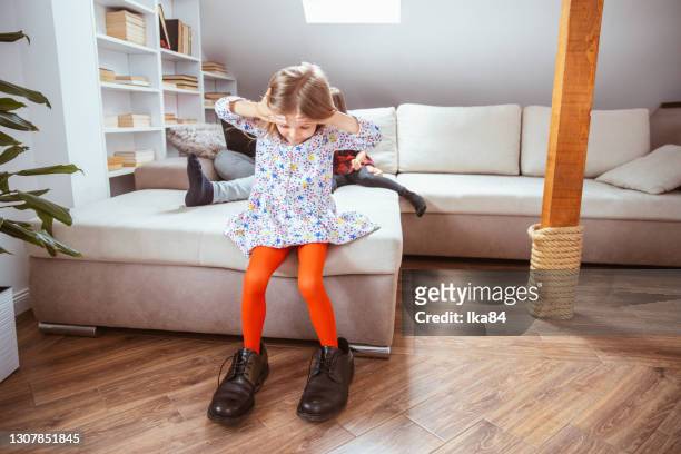 a girl in big daddy's shoes - big foot stock pictures, royalty-free photos & images