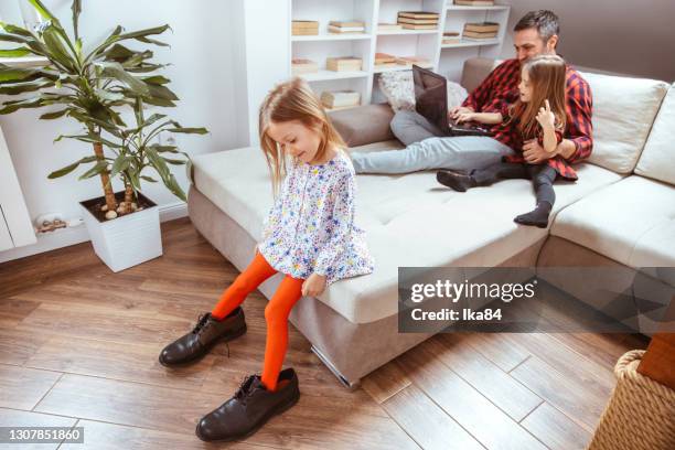 a girl in big daddy's shoes - kid in big shoes stock pictures, royalty-free photos & images