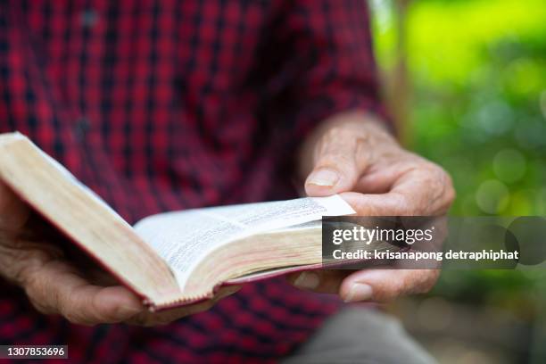 old woman and man reading the holy bible,bible. - roman god stock-fotos und bilder