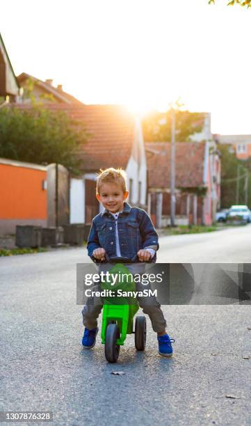 boy's ride around the neighborhood - 4 wheel motorbike stock pictures, royalty-free photos & images