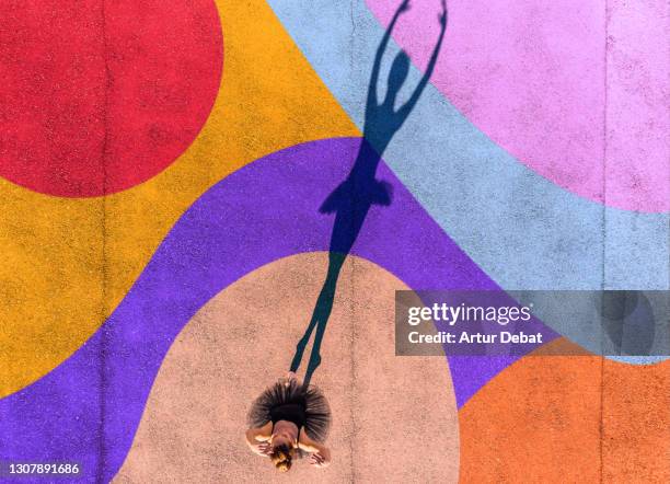 directly above view of ballerina dancing with colorful art in the ground.. - performance stock-fotos und bilder