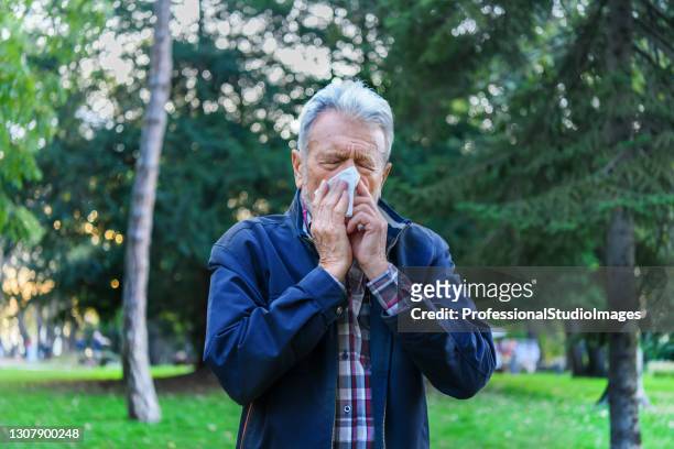 sick senior man caught a flu virus and high temperature. - blowing nose stock pictures, royalty-free photos & images