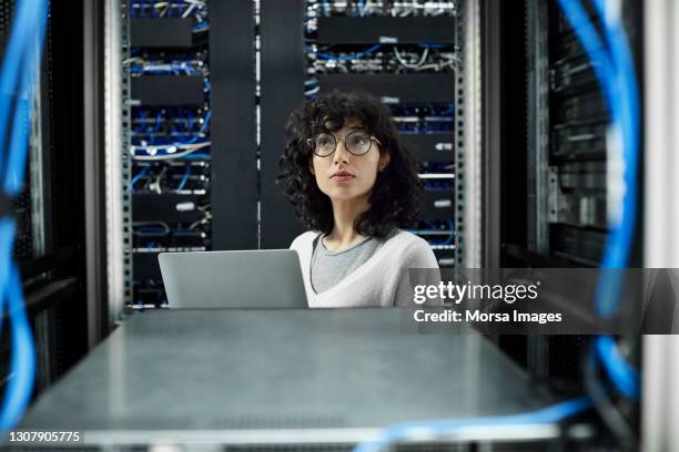 female technician standing in server room - data center foto e immagini stock