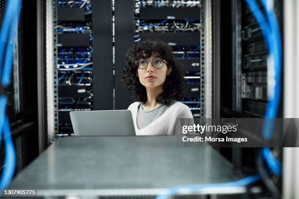 female technician standing in server room - old computer equipment stock pictures, royalty-free photos & images