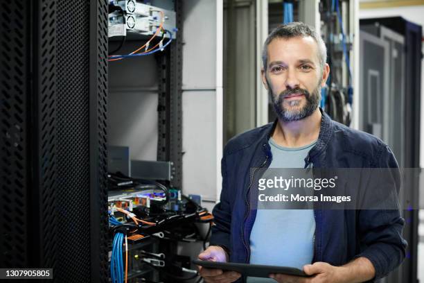 portrait of male engineer using digital tablet in server room - it professional imagens e fotografias de stock