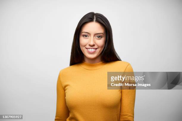 confident latin american businesswoman against white background - solo una donna giovane foto e immagini stock