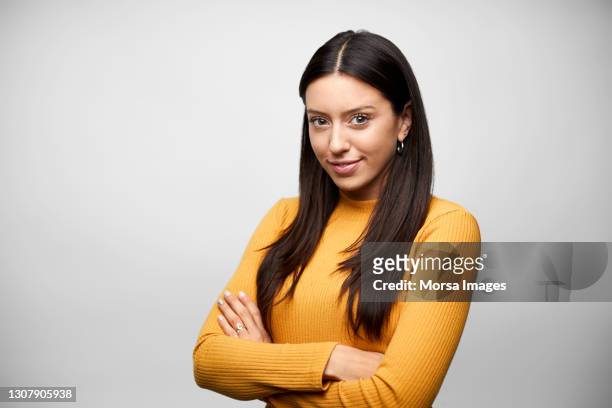 hispanic businesswoman against gray background - capelli castani foto e immagini stock