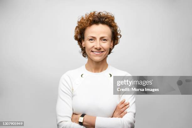 confident hispanic businesswoman against gray background - ミッドアダルト ストックフォトと画像