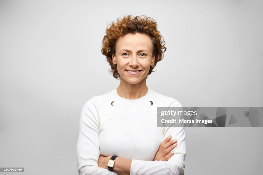 Confident Hispanic Businesswoman Against Gray Background
