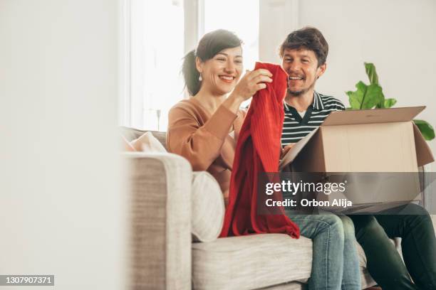 de openingsdoos van het paar thuis - online shopping opening package stockfoto's en -beelden