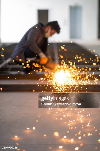 a worker is grinding welded joint - in flames i the mask stock pictures, royalty-free photos & images